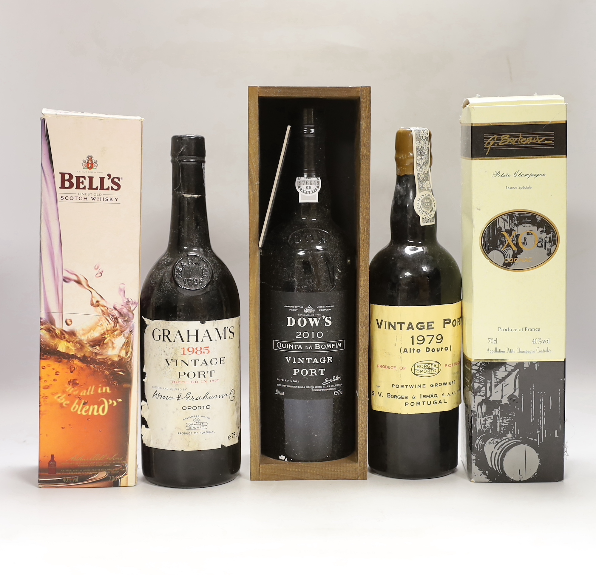 Three bottles of vintage port: A Grahams 1985, a Portuguese Alto Douro 1979, a Dow’s 2010 together with a boxed Bell’s Scotch whisky and a French XO boxed Cognac